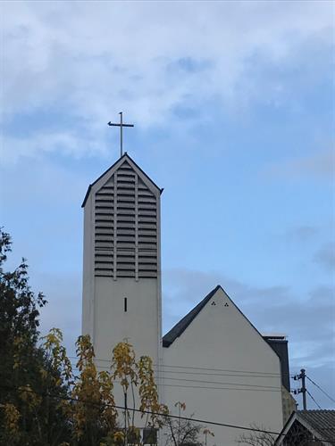 ein weißes Gebäude mit einem Kreuz auf der Spitze